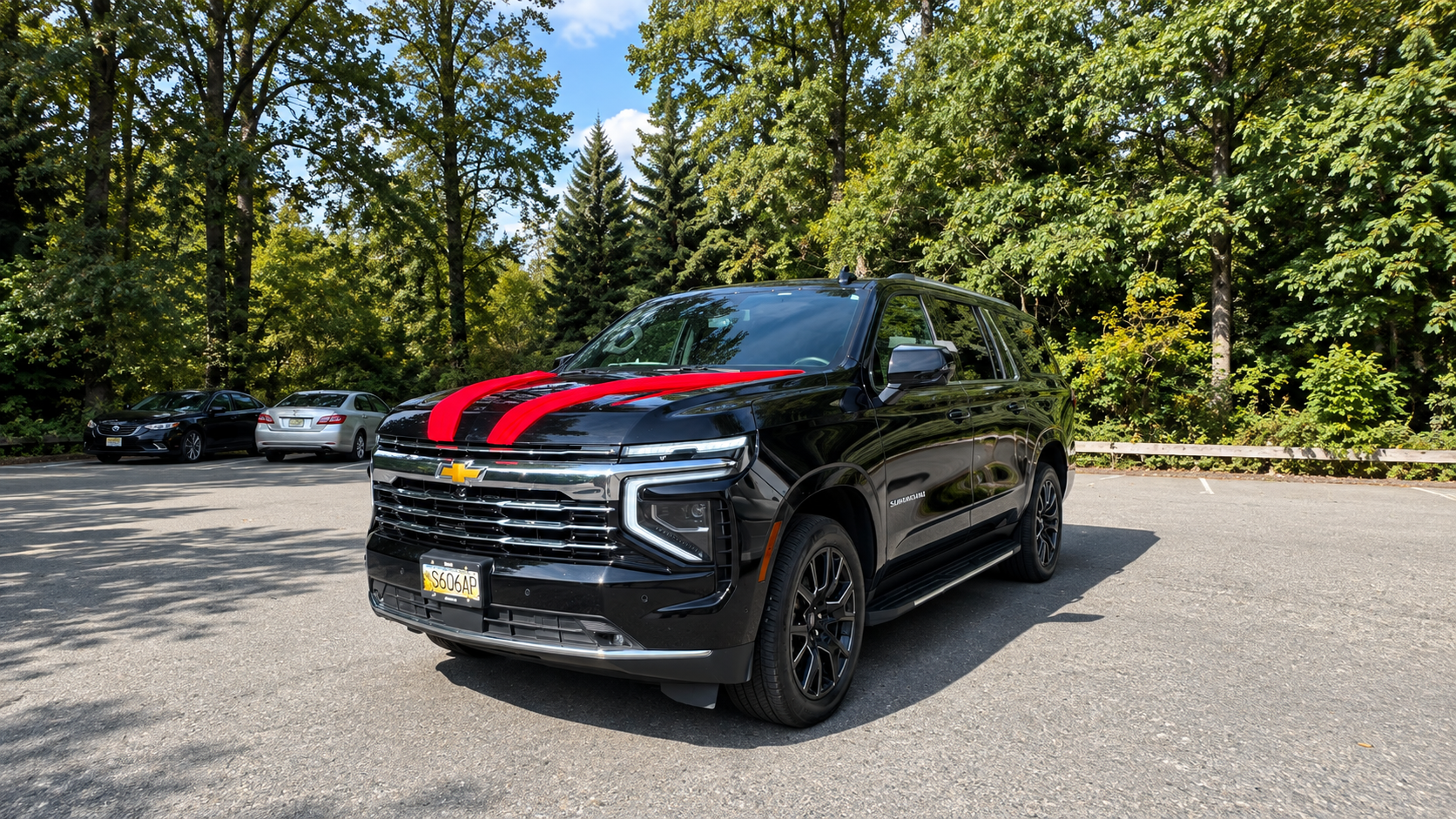 Black Chevrolet Suburban with red stripes, parked and ready for pickup